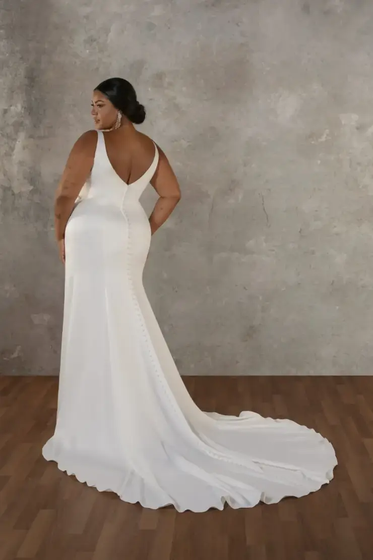 model is wearing a sleeveless sheath wedding dress