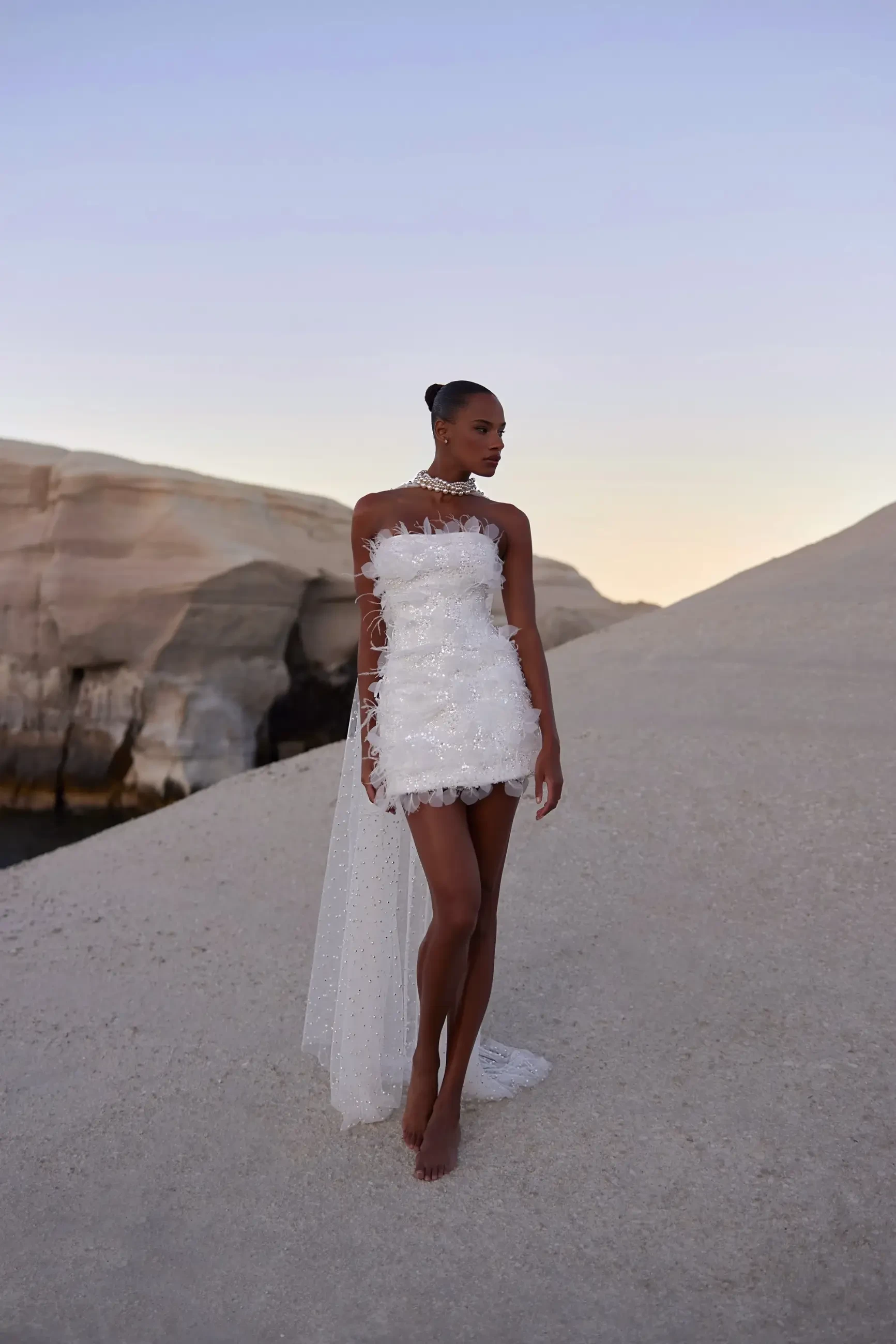 model is wearing a strapless mini bridal gown