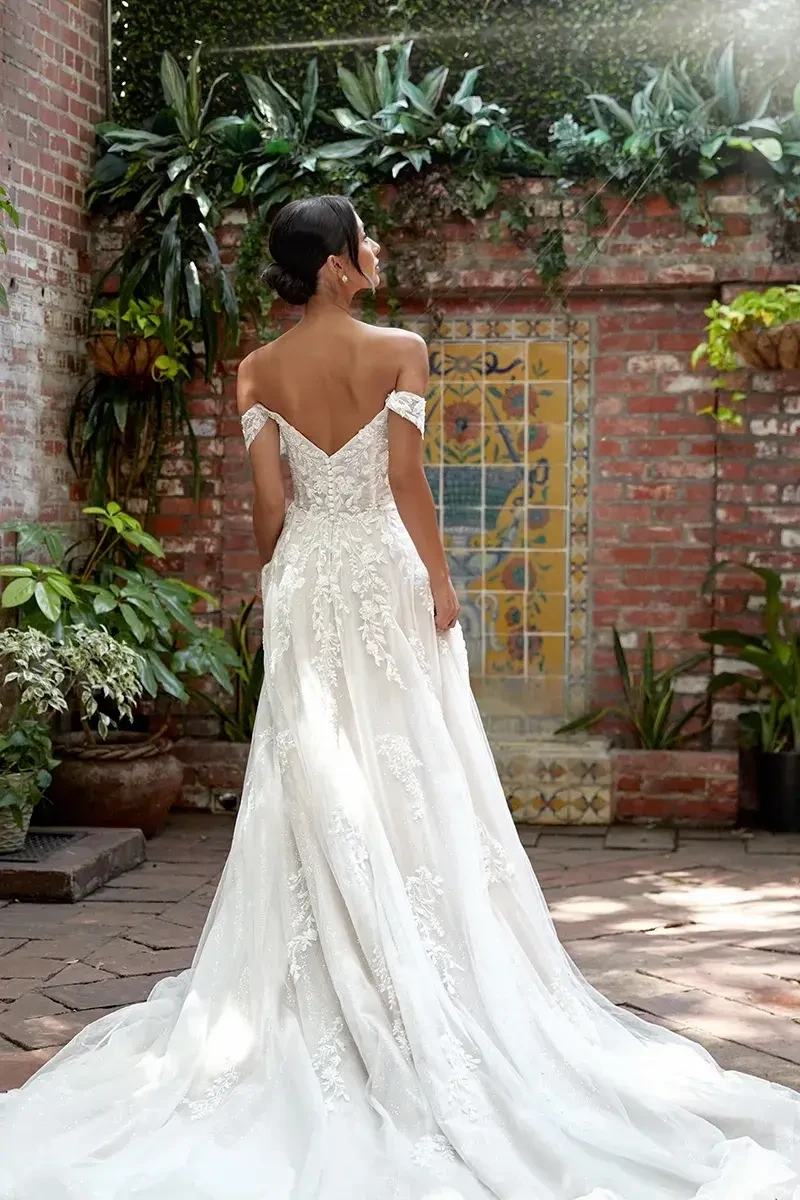 model is wearing an off the shoulder a-line bridal gown