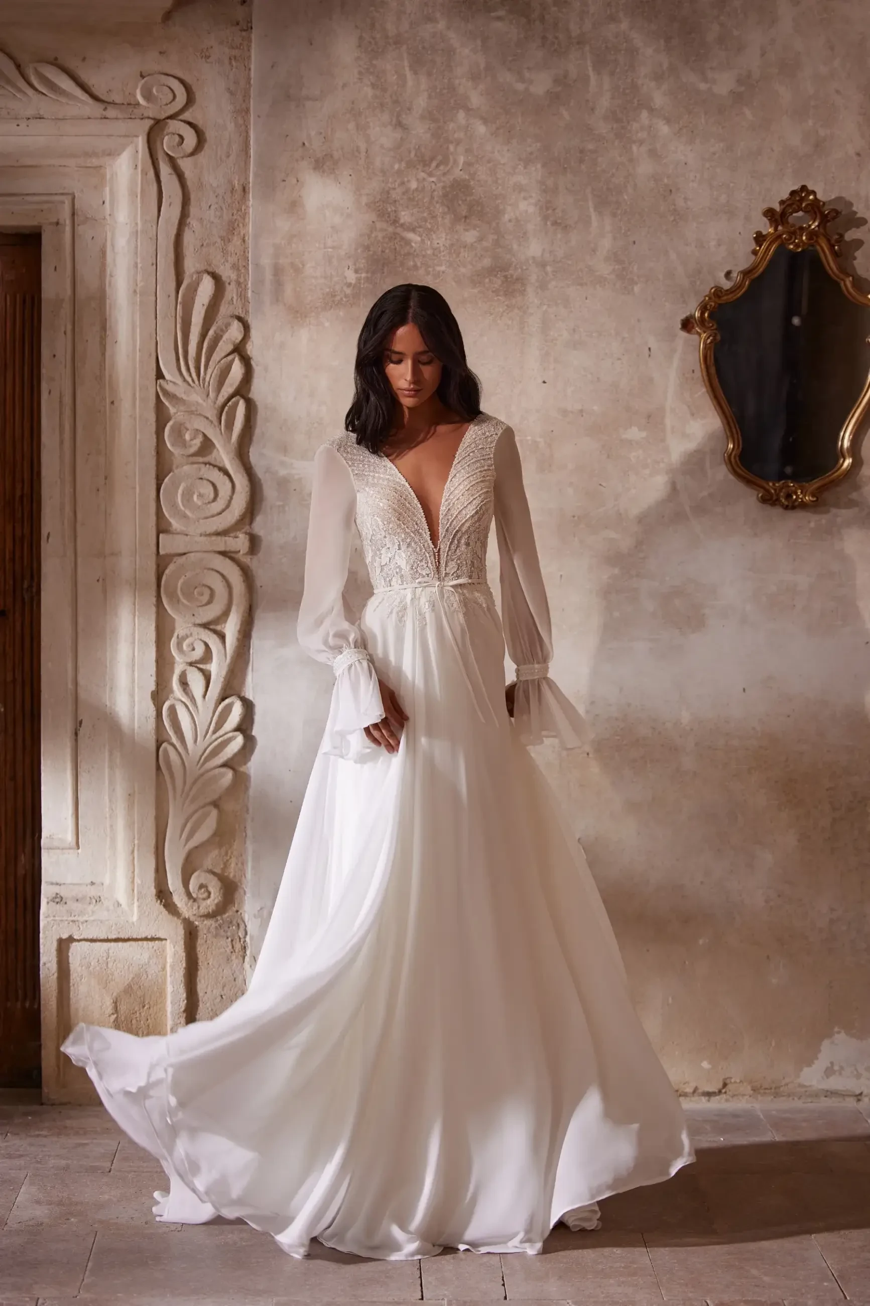 model is wearing a long sleeve a-line wedding dress