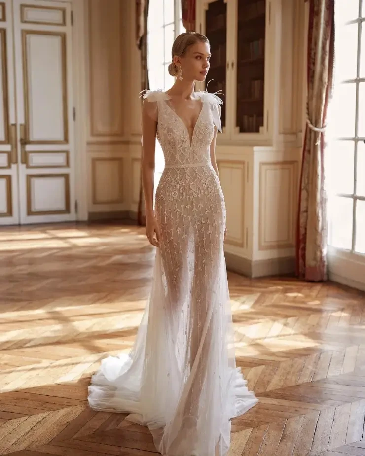 Beaded mermaid gown with a plunging neckline, open back, and delicate tie straps